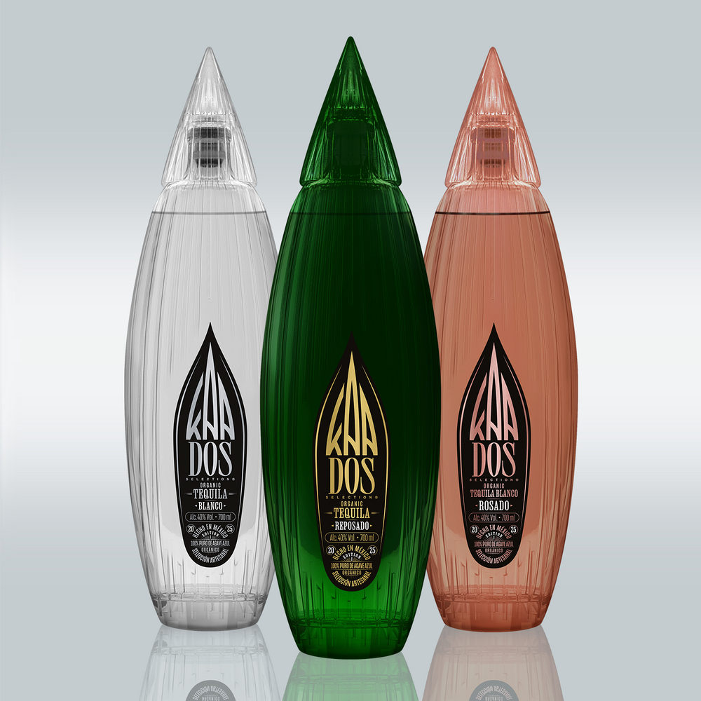 Three stylized tequila bottles made of glossy glass, standing upright against a light background. On the left: a clear bottle with a black label – “Tequila Blanco.” In the middle: a green bottle with a gold label – “Tequila Reposado.” On the right: a rose-colored bottle with a black label – “Tequila Blanco Rosado.” The bottles have a teardrop shape with vertical grooves and pointed caps.