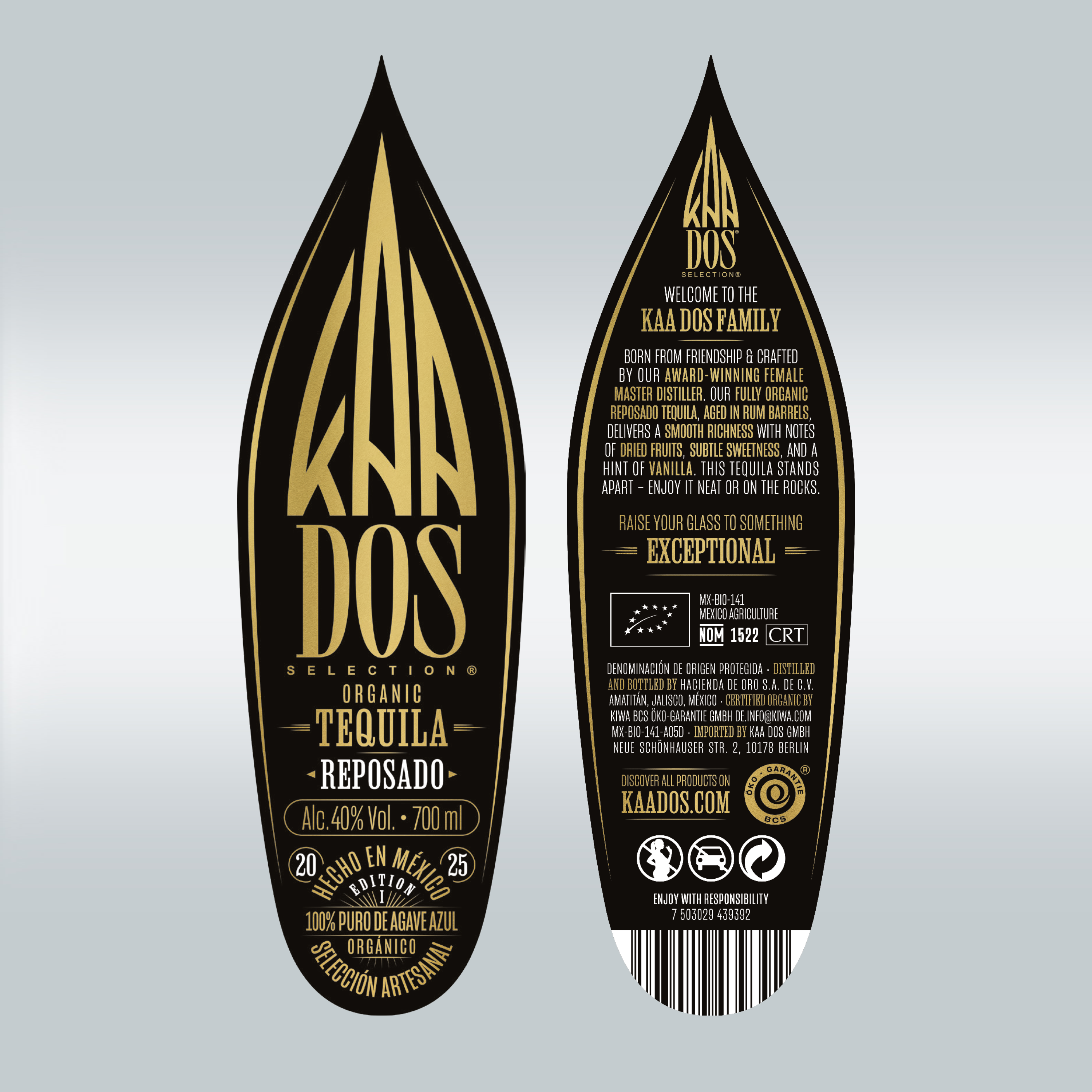 Close-up of KA DOS Reposado bottle labels, shaped like stylized agave leaves. Front label in gold on black reads: “Organic Tequila Reposado”, 40% vol., 700 ml, and “100% Puro de Agave Azul”. Back label highlights aging in rum barrels, tasting notes of dried fruits and vanilla, and brand story centered on a female master distiller. Includes CRT and NOM 1522 certifications, website, and barcode.